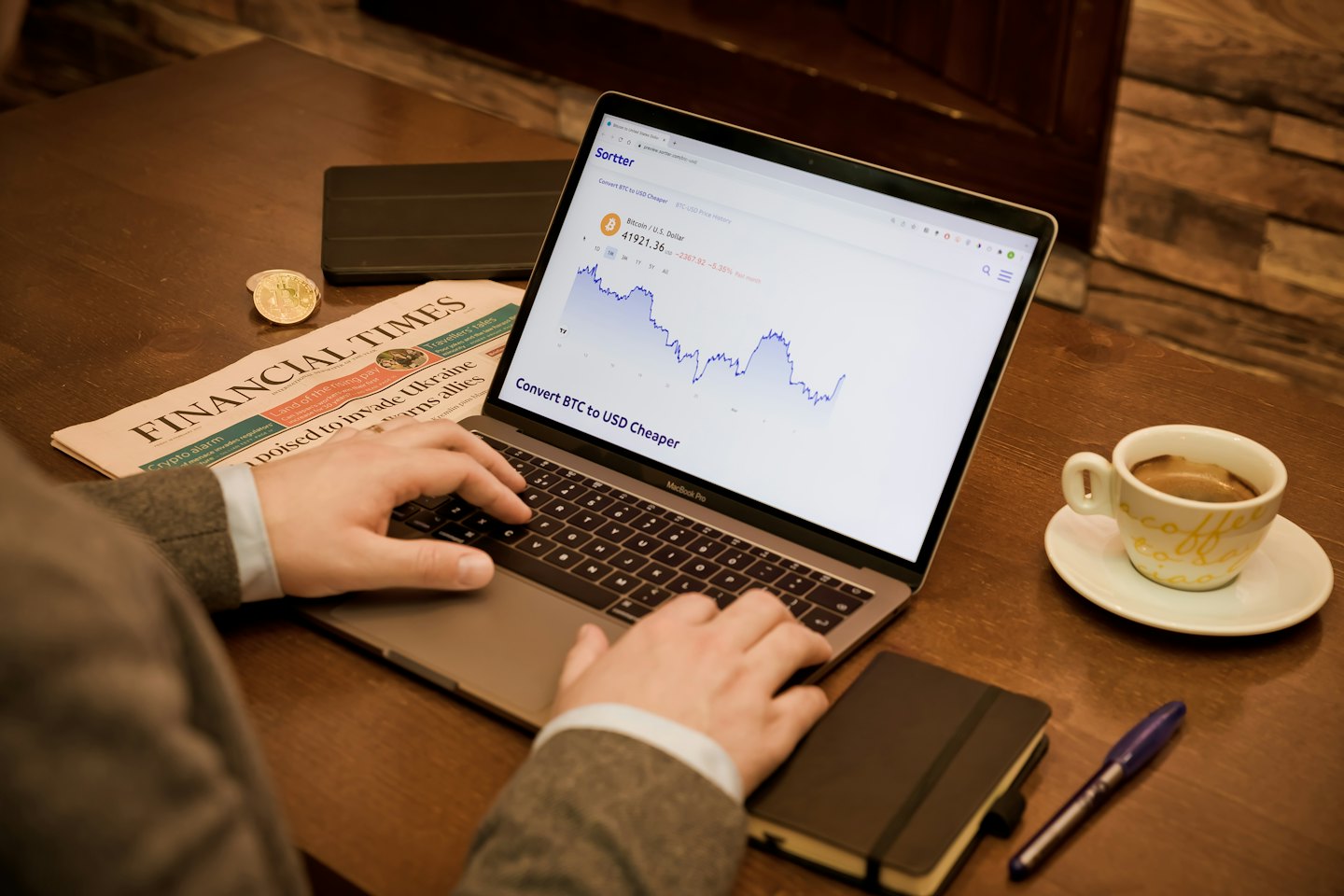 Person tippt auf einem Laptop mit Kryptowährungsmarktdaten.